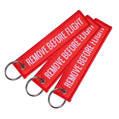 Vyšívaný přívěsek na klíče "Remove Before Flight"